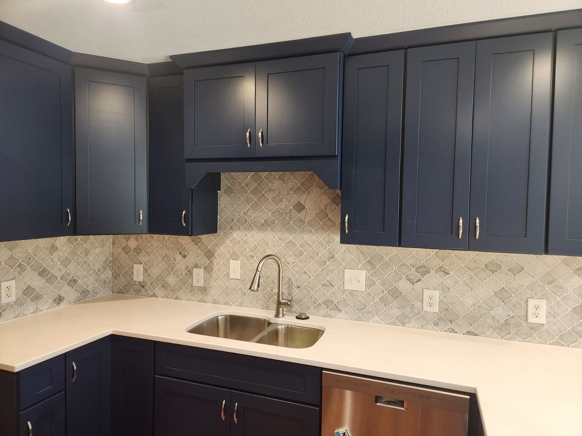 Kitchen Remodel With White Countertops and Blue Custom Cabinetry With Stainless Steel Fixtures And Backsplash By True Craft Remodelers