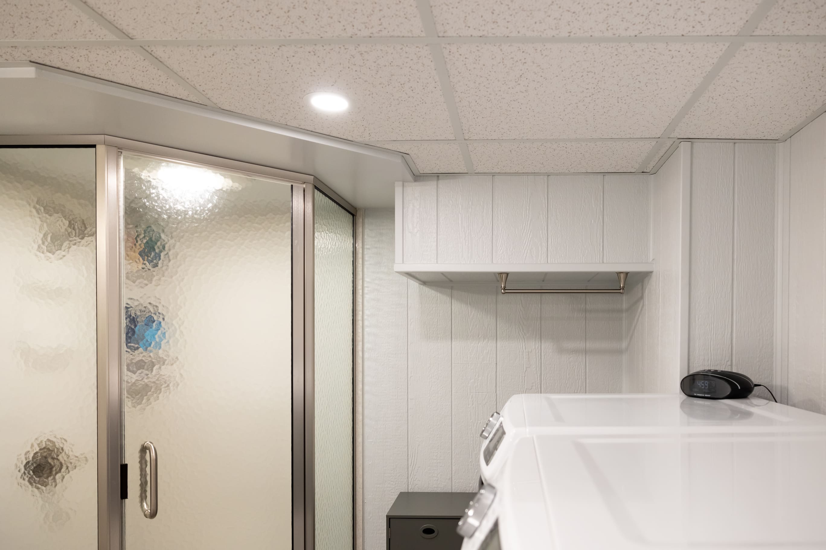 Bathroom with shower and laundry area in basement remodel