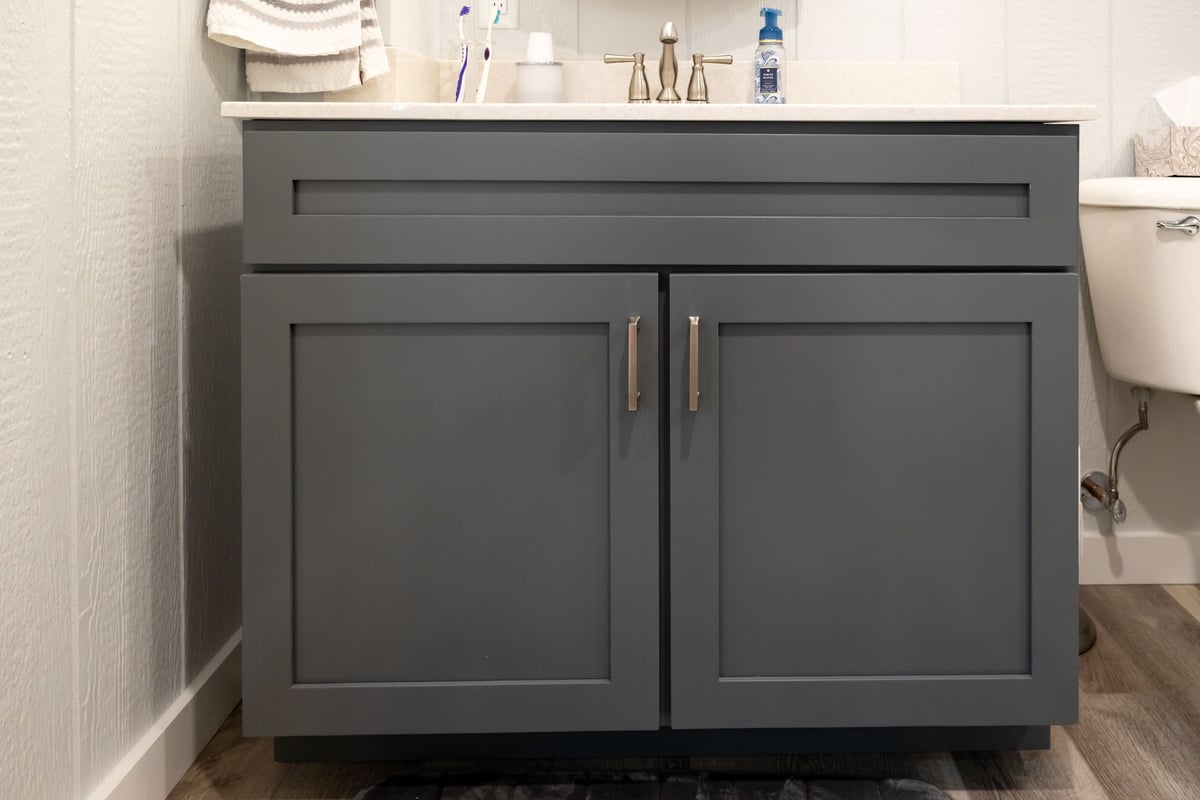 Grey cabinets with white countetop vanity in bathroom in basement remodel