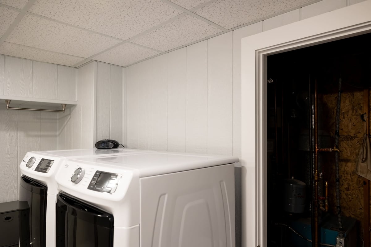Open door to water closet next to washer & dryer in basement remodel-2