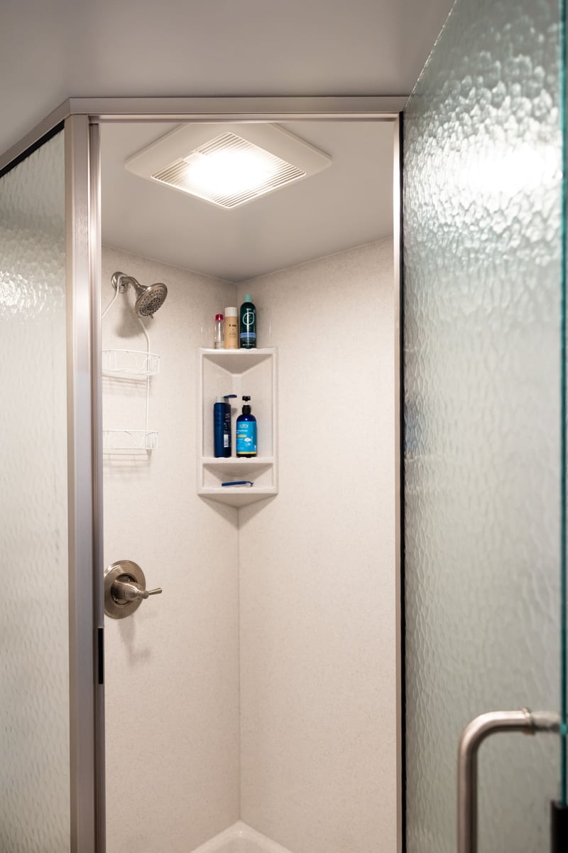 Open door to white shower in basement remodel