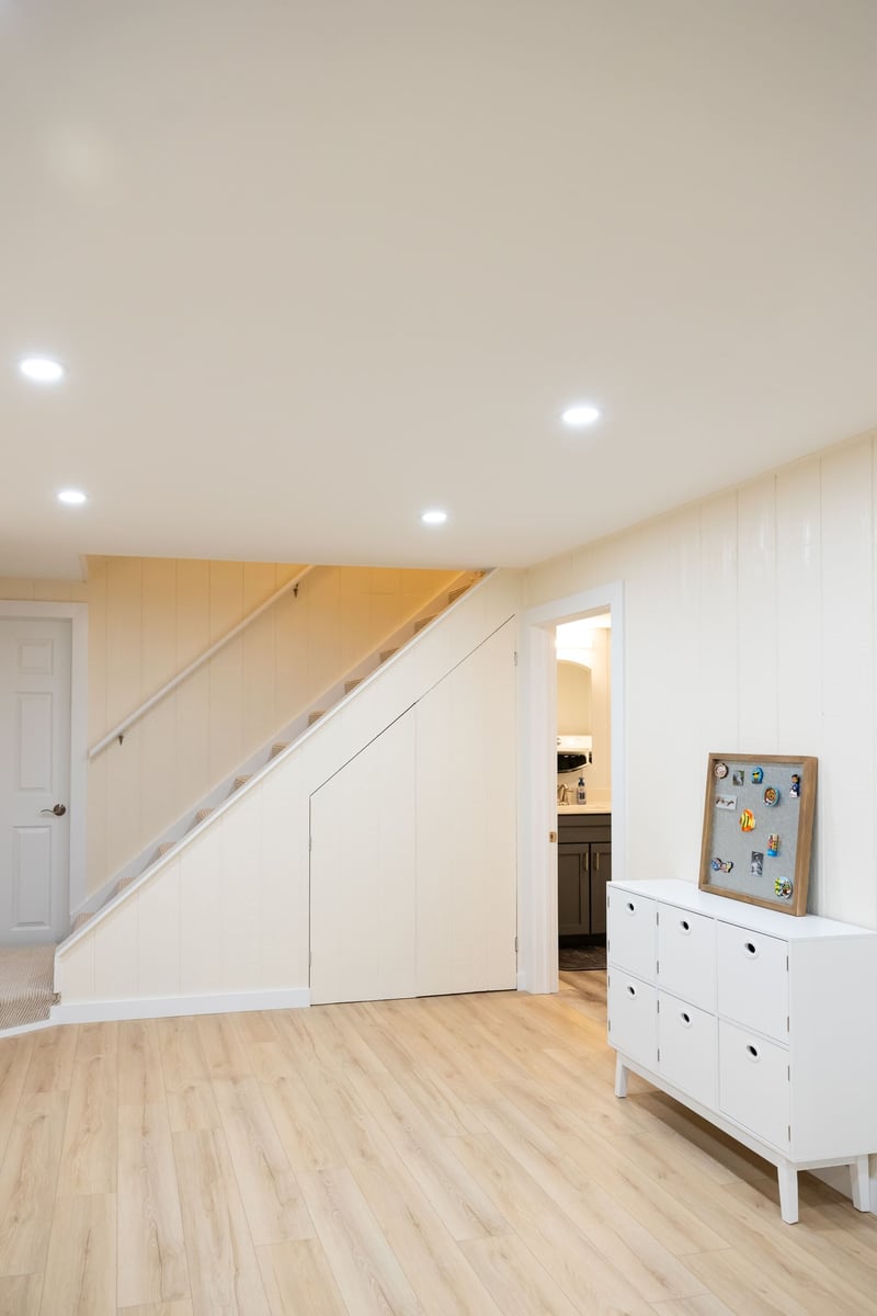 Staris leading to first floor in bright white open basement remodel