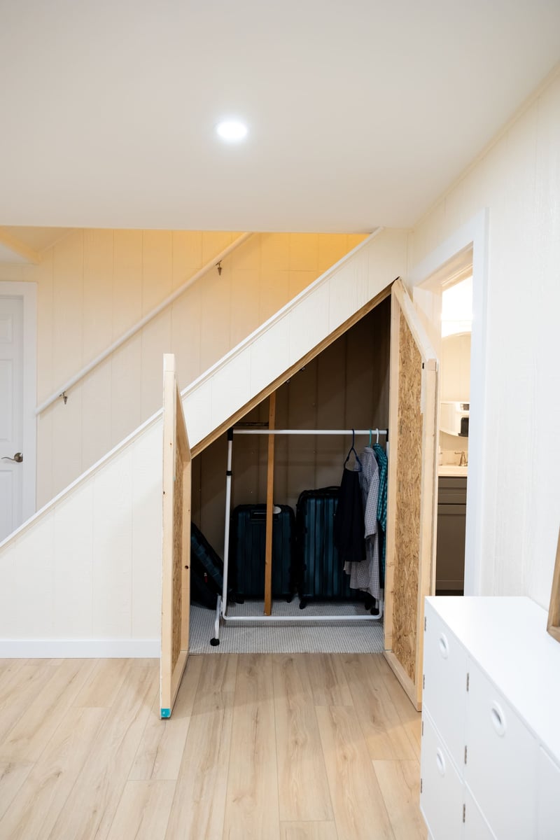 Under stairs closet with open doors in basement remodel