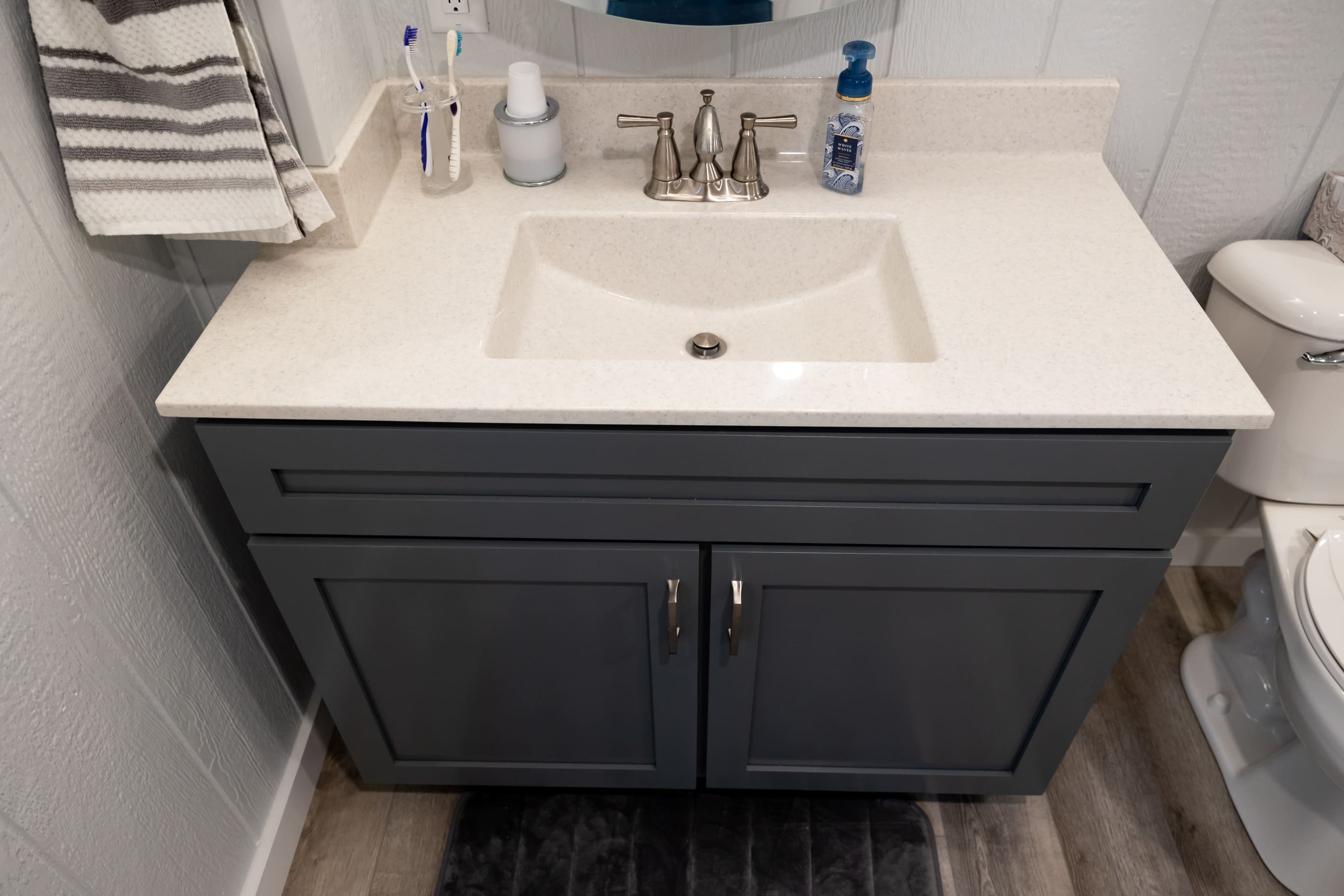 Vaniety with dark grey cabinets and white toliet in basement remodel-2