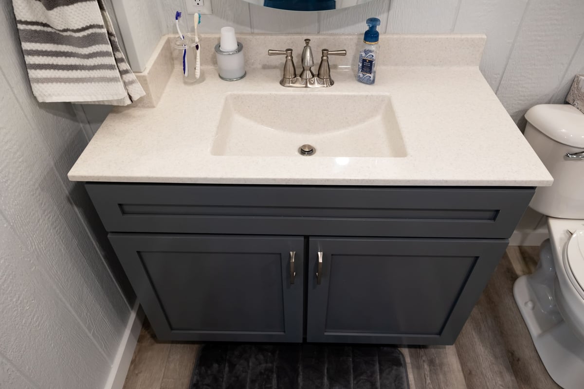 Vaniety with dark grey cabinets and white toliet in basement remodel-2