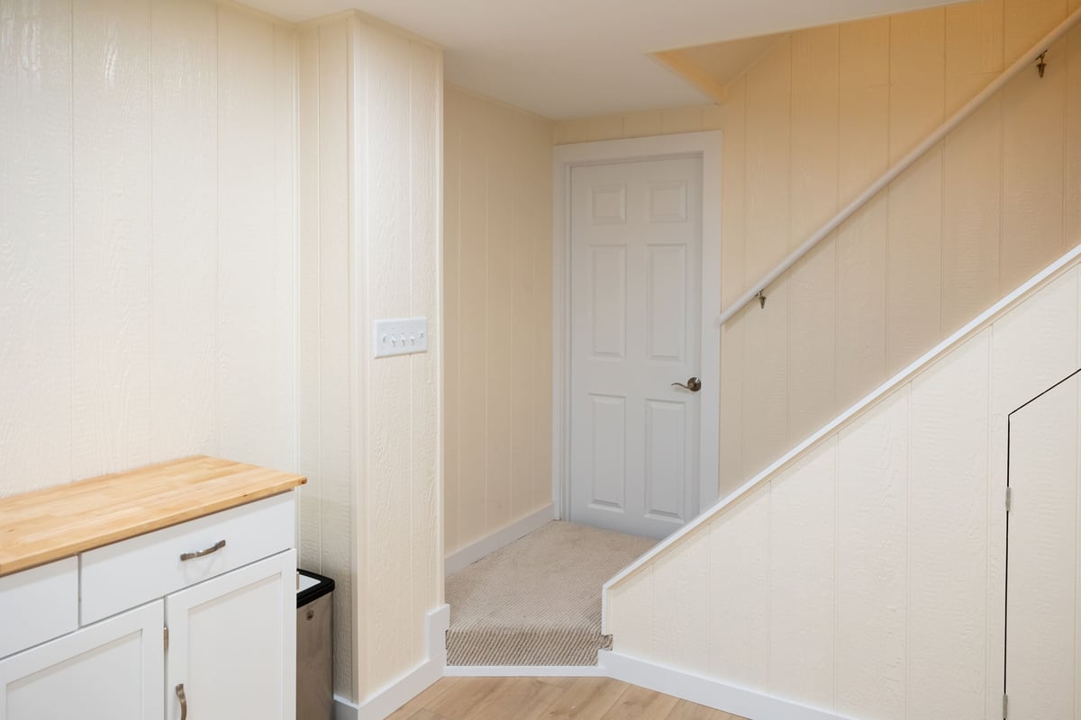 White door and stairway leading to first floor from basement remodel