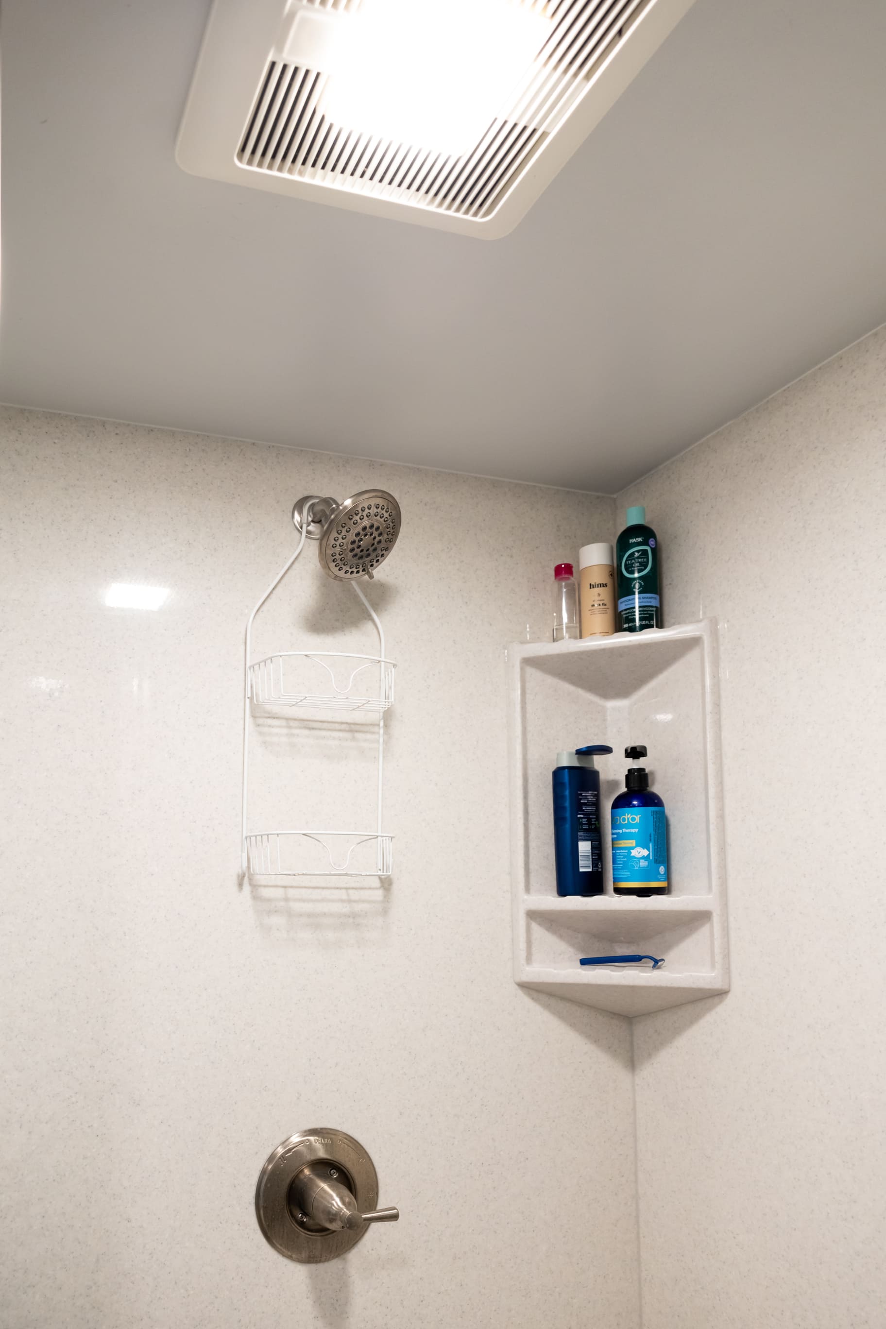 White shower with brushed silver fixtures in bathroom of basement remodel