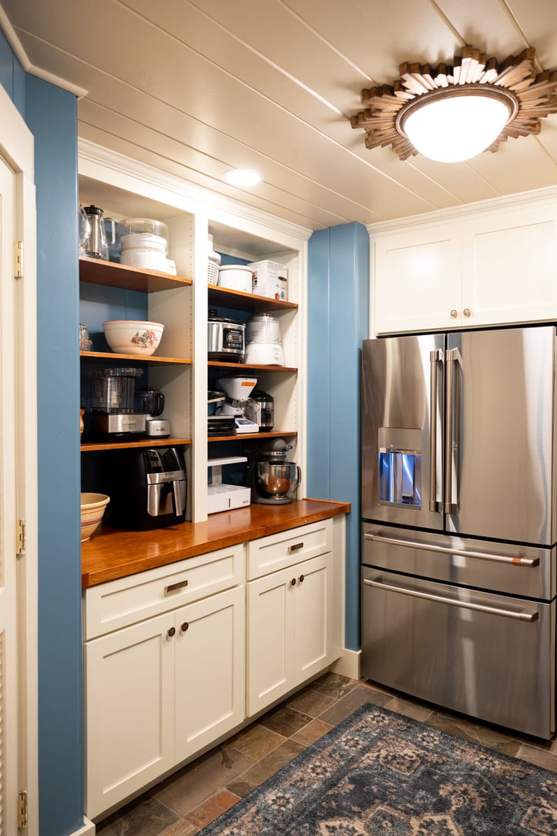 Refrigerator Kitchen with white cabinetry and wood countertops and shelves with blue and white walls and tile floor