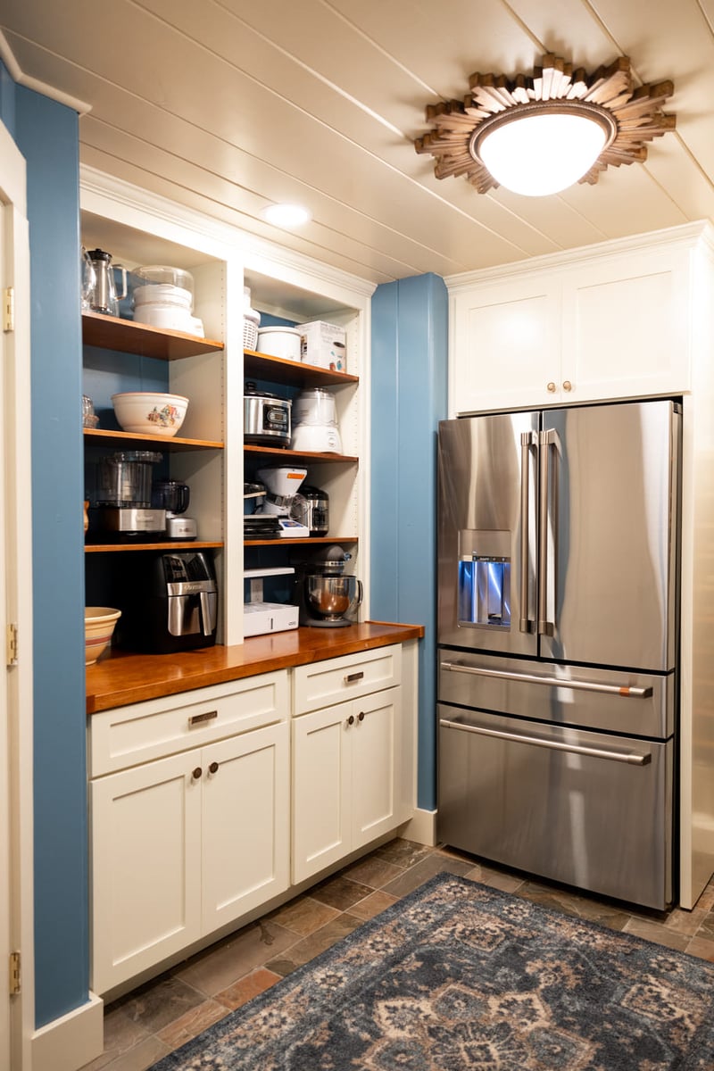 Refrigerator Kitchen with white cabinetry and wood countertops and shelves with blue and white walls