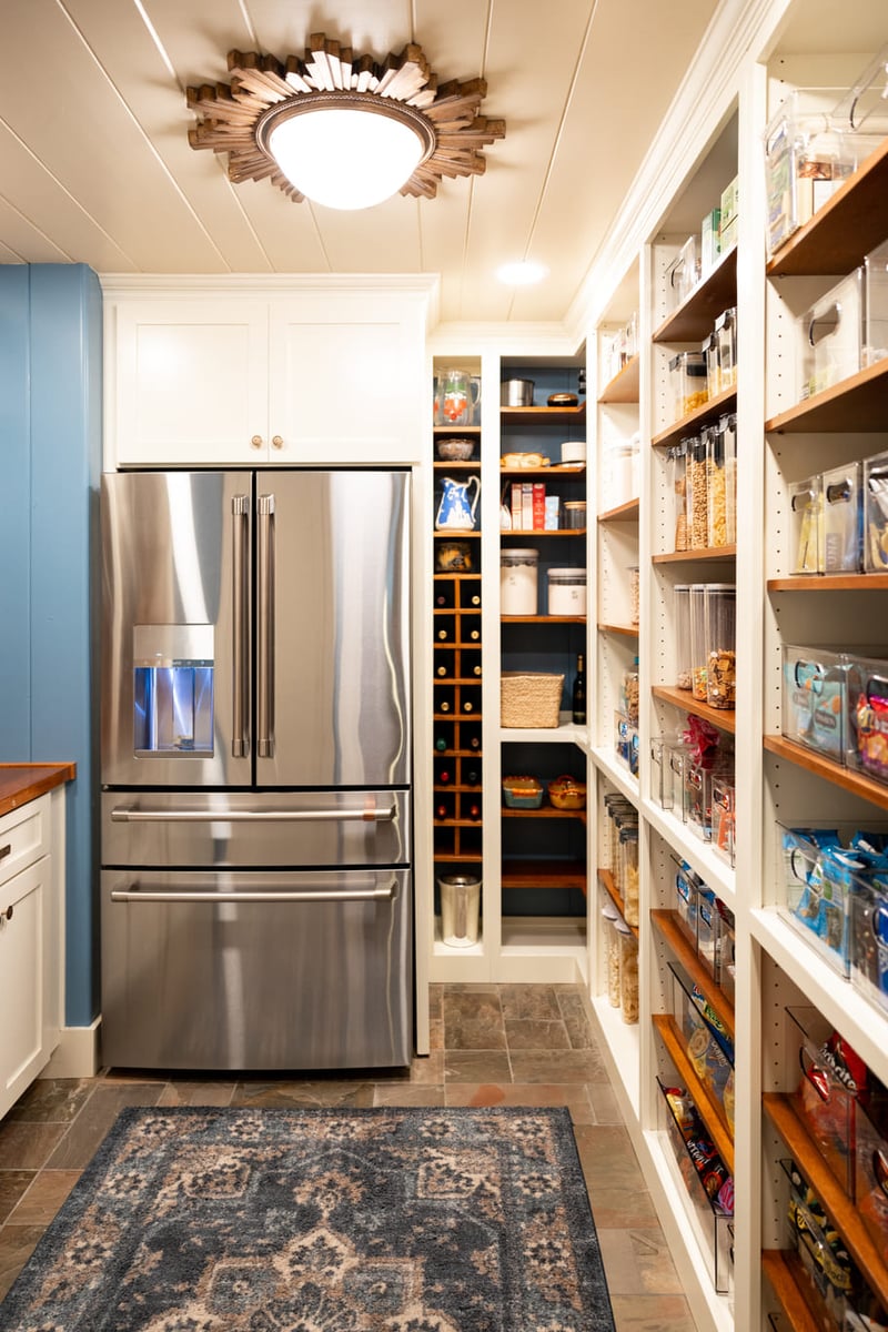 Refrigerator in kitchen with tiled floors, white custom shelving and storage areas with light blue walls