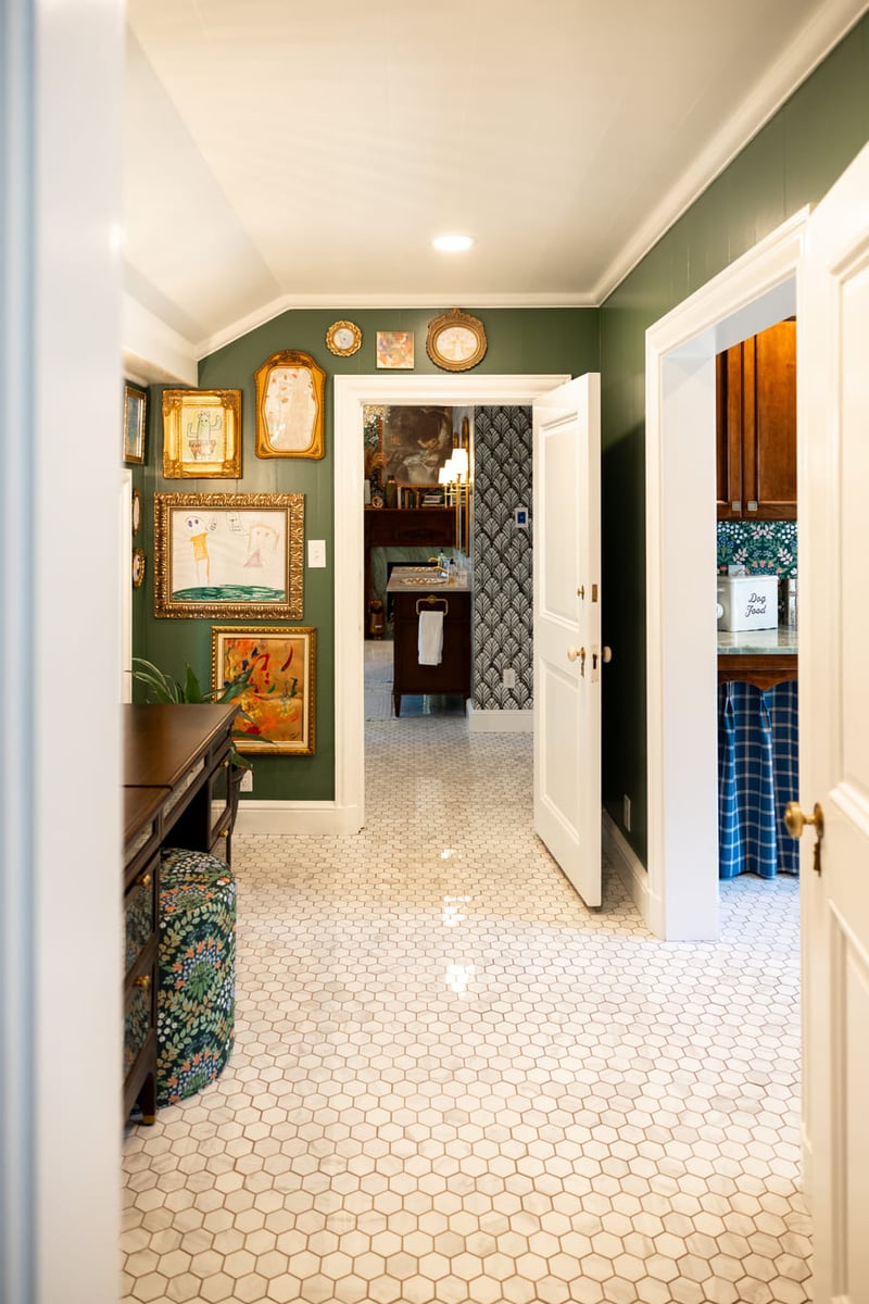 Vaniety area with white tiled floors and green walls leading to bathroom