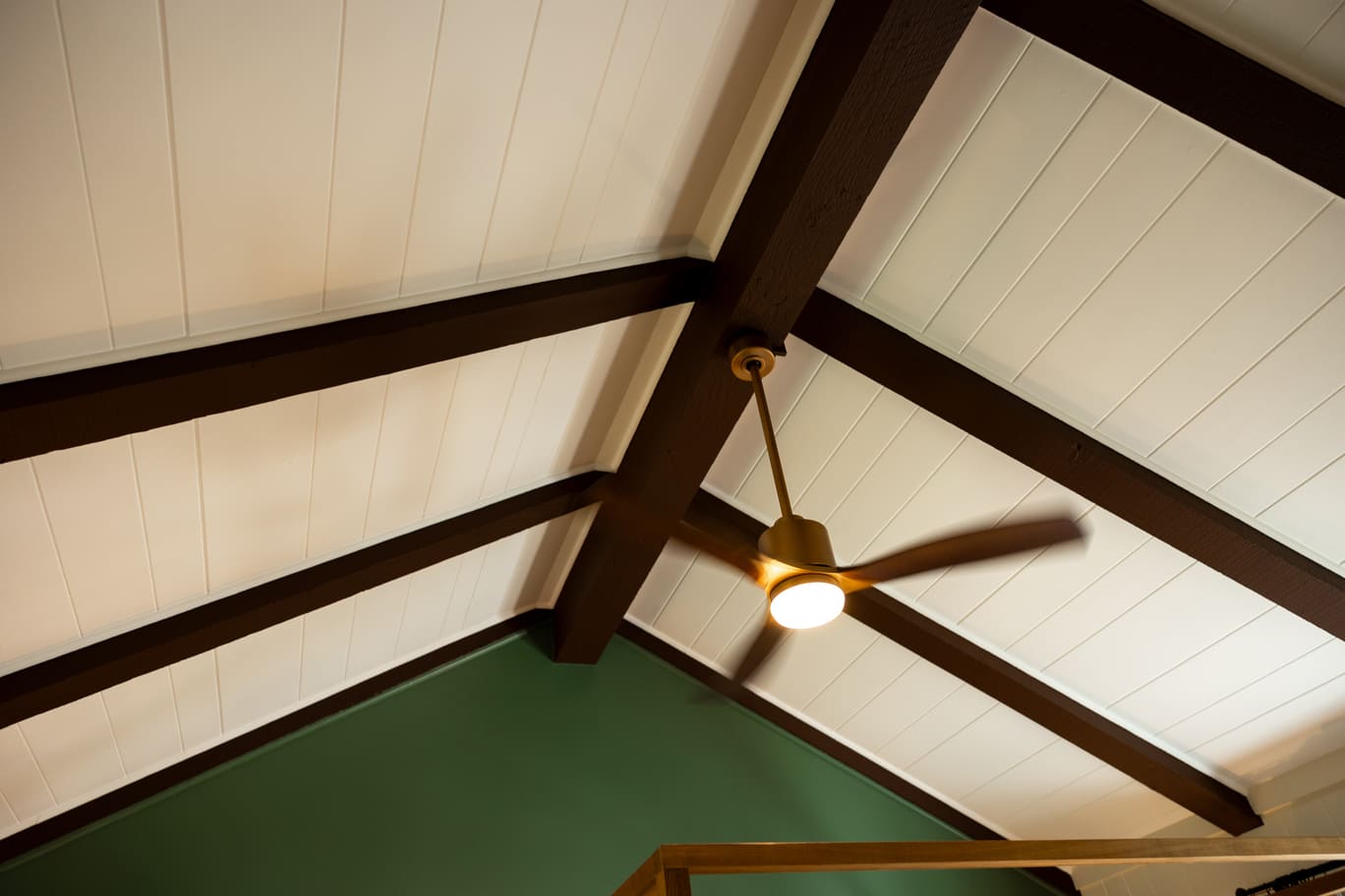 Vaulted white ceilings with green walls and fan