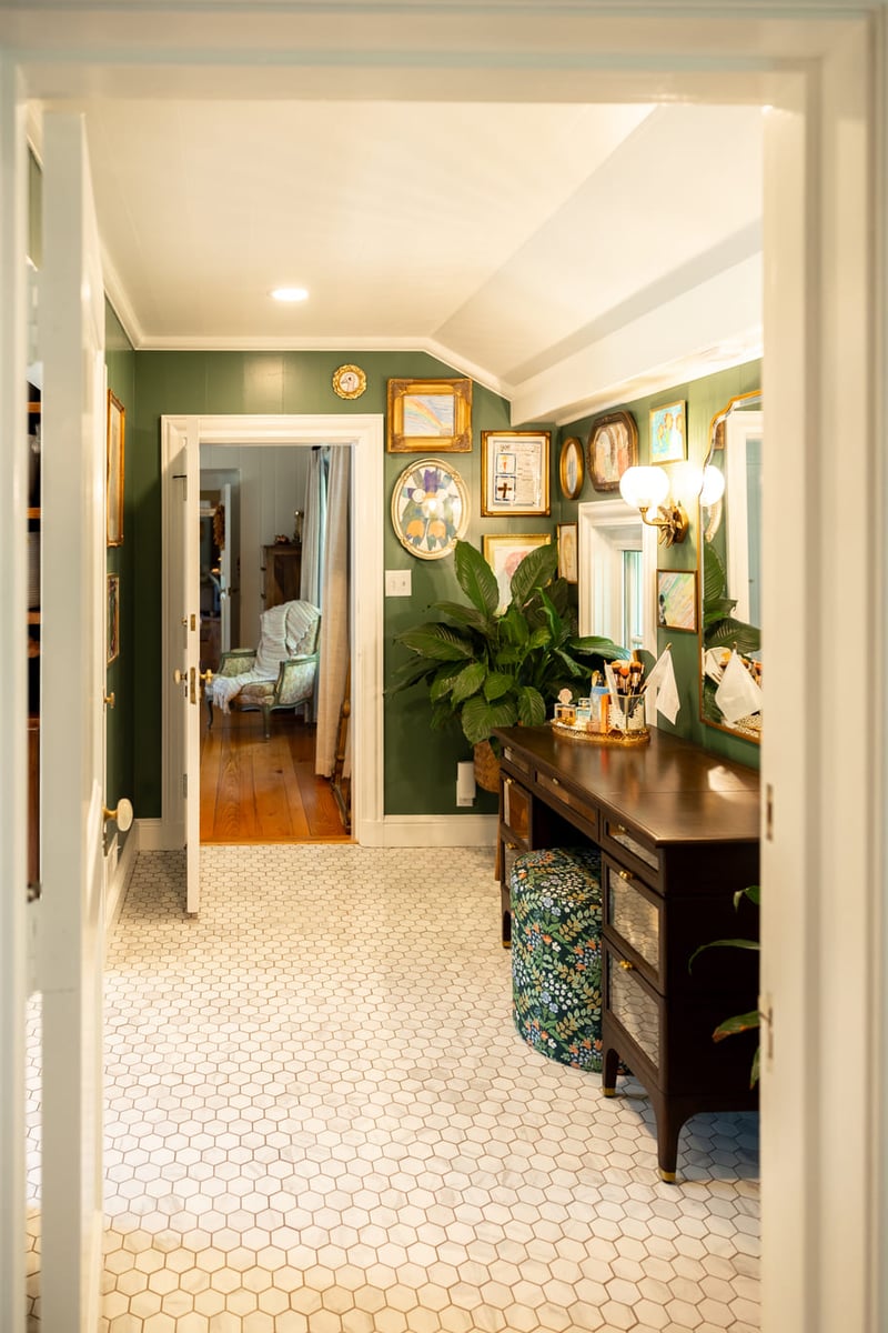 View of bedroom doorway and vaniety area with white tiled floors and green walls